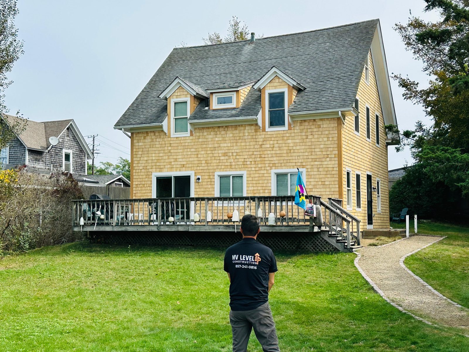 Owner Fabiano reviewing a finished cedar-sided home - MV Level Up Construction